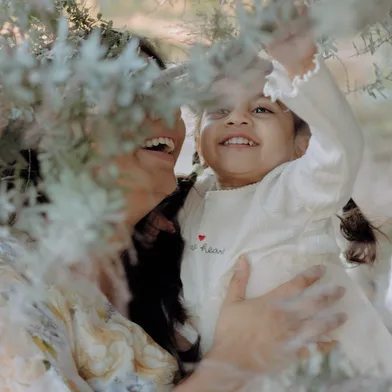 Mother and daughter laughing outdoors